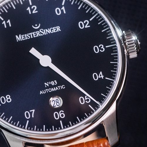 Das kreisrunde Datumsfenster besitzt blaue Ziffern. Das kreisrunde Datumsfenster besitzt blaue Ziffern.