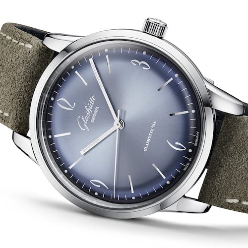 Das graubraune Kalbs-Nubuklederband wird mit einer Dornschließe geschlossen. Das graubraune Kalbs-Nubuklederband wird mit einer Dornschließe geschlossen.