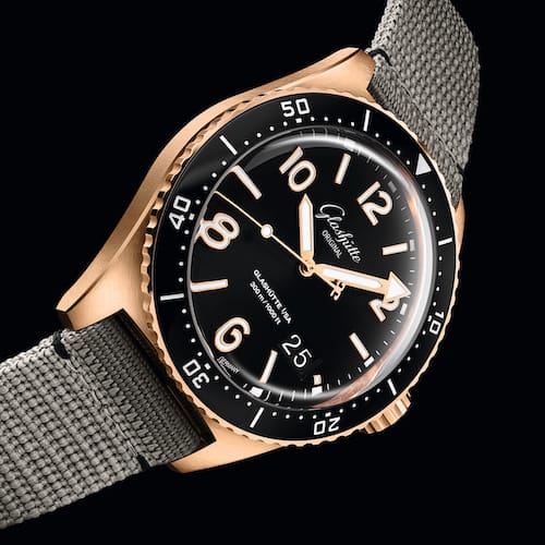 Glashuette-Original-SeaQ-Panoramadatum-Bicolor-1-36-13-03-90-34-Seite Die Rotgoldverson der Taucheruhr am grauen Synthetikband.