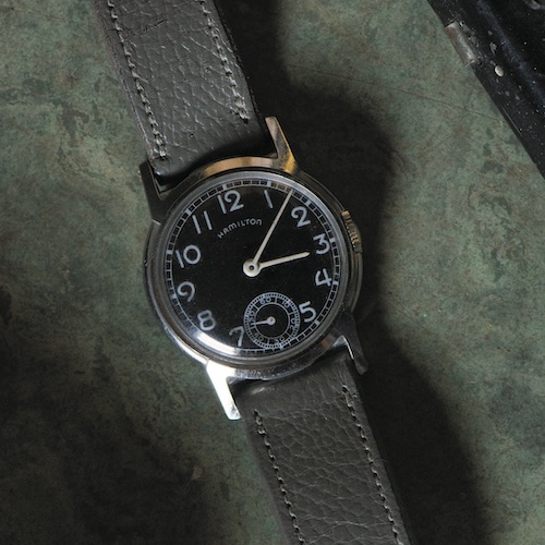 Hamilton Lexington Oppenheimer Die Hamilton Lexington mit schwarzem Zifferblatt wird an einem grünen Band getragen.