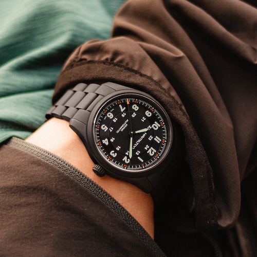 Hamilton Khaki Field Titanium H70215130 am Arm Die Version mit mattschwarzer PVD-Beschichtung besitzt ein schwarzes Zifferblatt.