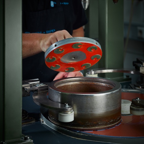 Wyoming-Jade_Schleifmaschine Die montierten Jade-Zifferblätter vor dem Abschleifen auf die gewünschte Höhe.