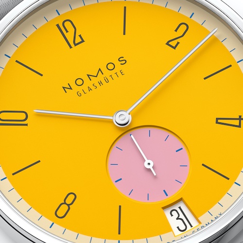 Nomos Glashütte Tangente 38 Datum Katzengold Wie der Name andeutet, hat das Modell Katzengold ein Zifferblatt in warmem, goldenem Gelb, abgesetzt durch eine kleine Sekunde in Pink.