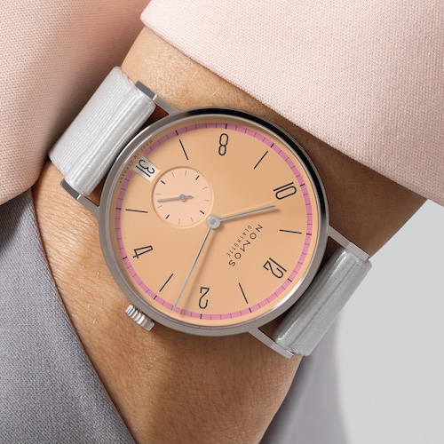 Nomos Glashütte 21 Tangente 38 Datum Pastell Obgleich Tangente Datum Pastell zart scheint, verfügt sie über ausgeprägten Charakter und setzt sich deutlich von Creme- und Rosatönen ab, die man sonst oft sieht.