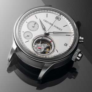 Das goldene Zifferblatt ist rhodiniert, der Stunden- und Minutenring ist graviert und schwarz lackiert. Die Chronographenanzeigen sind aus Weißgold.