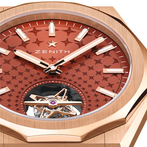 Das ziegelrote Zifferblatt ist mit einem sternförmigen Muster versehen, das auf das Tourbillon zuläuft.