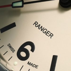 Das Zifferblatt ist mit gedruckten arabischen Stundenziffern bei drei, sechs, neun und zwölf Uhr versehen.