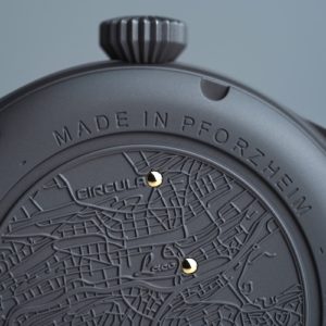 Zwei goldene Punkte auf dem Gehäuseboden zeigen die historischen Firmensitze beider Marken.