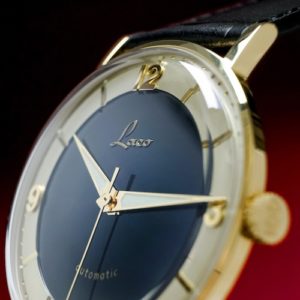 Die Zeiger sind goldfarben beschichtet und mit Leuchtfarbe ausgefüllt.