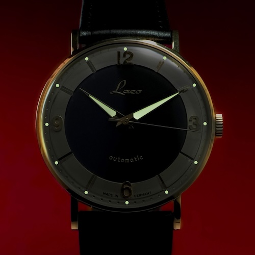 Stunden- und Minutenzeiger und die Indexpunkte sind im Dunkeln ablesbar.