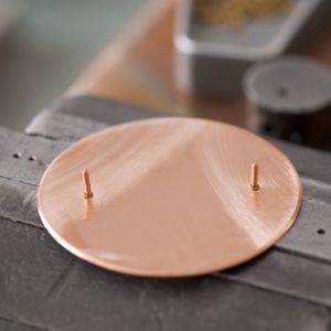 Der Metallrohling aus Messing oder Silber wird oft beidseitig emailliert, um Spannungen zu vermeiden.