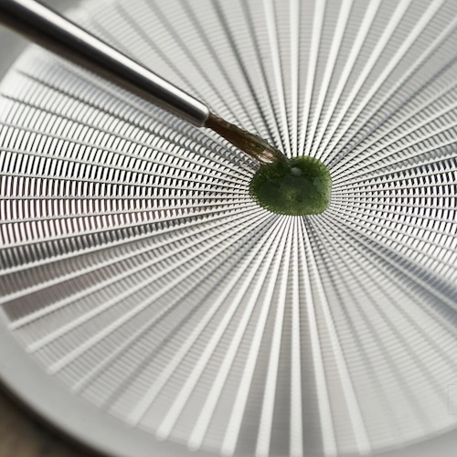 Flinque-Emaille Beim Flinqué-Verfahren wird die Schicht über einer Guillochierung aufgebracht, die anschließend durchscheint.