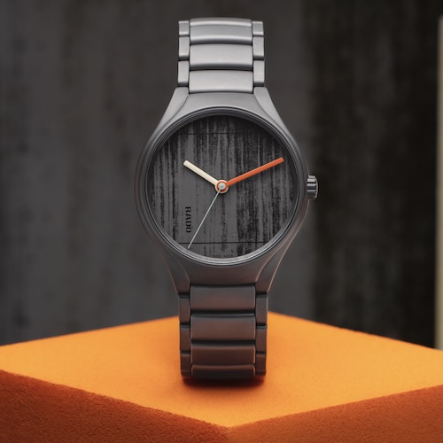 Die lackierten Zeiger stehen im Kontrast zu dem Zifferblatt, das mit einer betonähnlichen Struktur versehen ist.